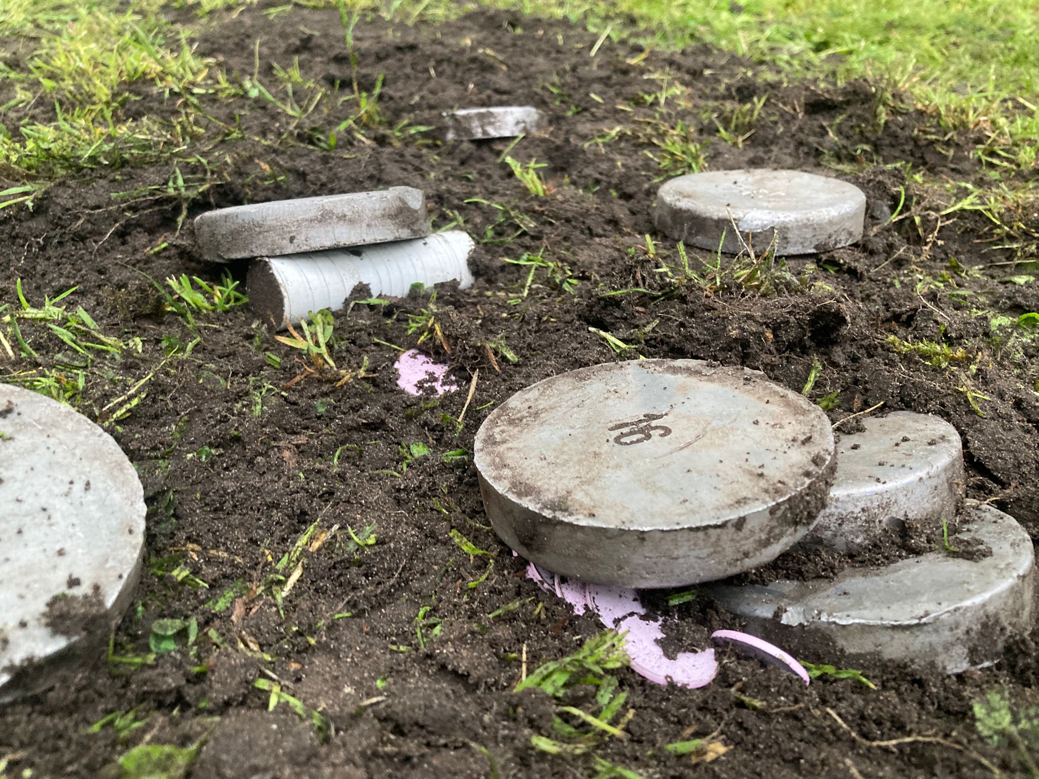 Werpschijven verspreid rond de omgevallen paap en muntstukken